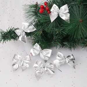 Close-up of sparkling silver glitter Christmas bows on festive green pine branches