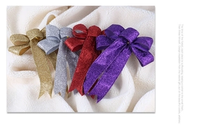 Glitzernde gold silber rot und lila Weihnachtsschleifen auf weichem weißem Stoff