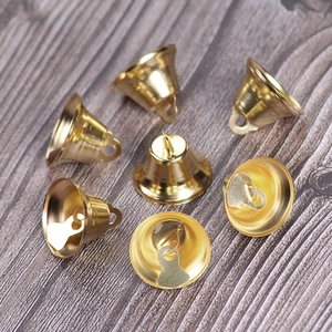 Macro detail of seven polished golden metal Christmas bells for DIY crafts decoration