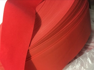 Gros plan sur un rouleau de ruban floqué rouge avec texture tissée pour décor de Noël