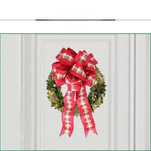 Close-up of a red and green plaid Christmas bow with pine cones and golden ornaments