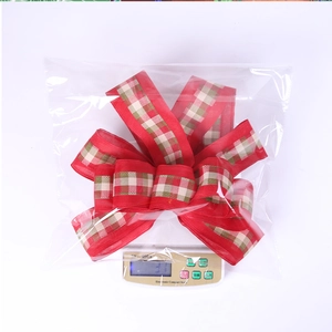Macro view of red and green plaid festive bow ornament on a digital scale for weight display