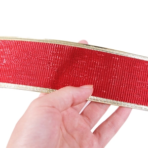 Detail of 10m red ribbed Christmas ribbon with gold metallic edges for gift wrapping