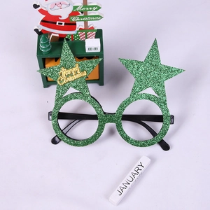 Detail view of green glitter star glasses with golden Merry Christmas lettering on frame
