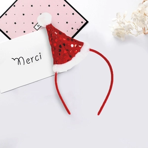 Detail van rode pailletten kerstmuts hoofdband met witte pluche pompon en decoraties