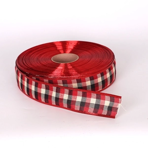 Close-up of red and black Scottish plaid ribbon roll with metallic layer for Christmas décor
