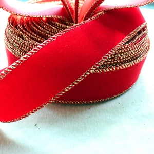 Detail of red velvet Christmas ribbon with gold wire edges for holiday tree decoration