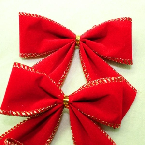 Close-up of a red velvet Christmas bow with gold metallic wired edges for tree decoration
