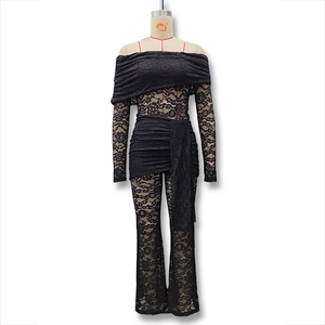 Detailed view of black lace off-shoulder top with ruffle neck and sheer wide-leg pants