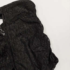 Detailed close-up of intricate black floral lace pattern with hollow embroidery texture