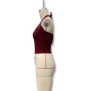 Detail eines burgunderroten Neckholder-Crop-Tops mit rückenfreiem Design auf Büste