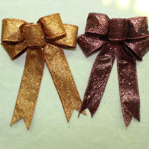 Close-up of dual-color Christmas bows in bronze gold and wine red with glitter finish