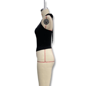 Detailansicht eines schwarzen Halterneck-Crop-Tops mit Schnürrücken auf einem Torso