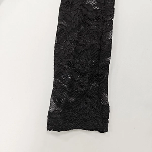 Close-up of intricate black floral lace fabric with honeycomb mesh and refined details