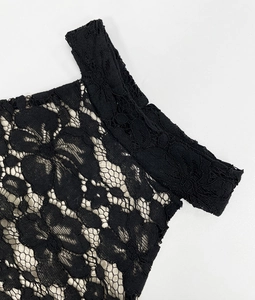 Gros plan sur la dentelle florale noire sur doublure beige avec bords cousus