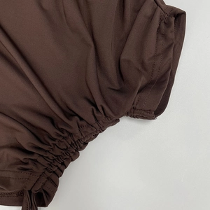 Vue détaillée des fronces et de la texture du tissu marron chocolat sur une jupe