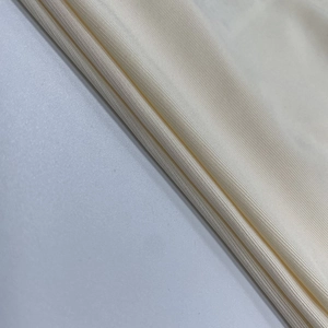 Detailansicht der cremefarbenen Rippstrick-Stoffstruktur des rückenfreien Neckholder-Tops