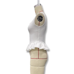 Vue latérale du haut blanc sans manches avec ourlet à basque sur un mannequin de couture