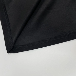 Dettaglio delle cuciture piatte e della trama a maglia fine su un abito nero elegante