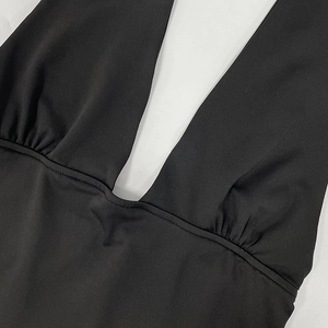 Close-up of black deep V-neck bodysuit showing detailed stitching and pleated design