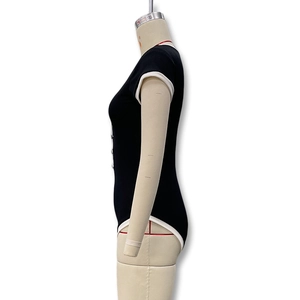 Détail du liseré blanc contrasté sur l'emmanchure de ce body noir à coupe moulante