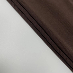 Détail du tissu en maille côtelée marron foncé montrant la texture verticale
