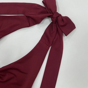 Detailaufnahme aus weinrotem Rippstoff mit einem zarten Schleifendesign zum Binden