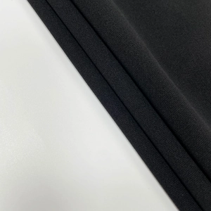 Dettaglio del tessuto crepe nero pregiato che mostra la trama a maglia complessa