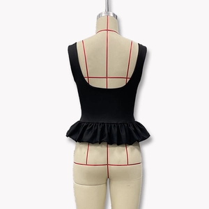 Détail du haut noir sans manches à basque avec col en U et dos nu sur mannequin