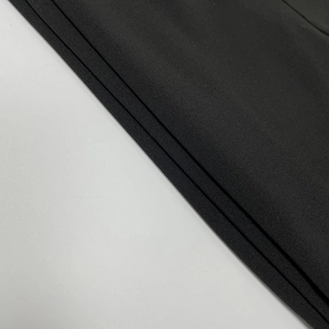 Close-up of black elastic knit fabric texture showing seamless quality and fine mesh detail