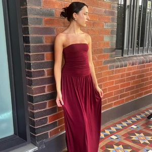 Vue détaillée d'une robe bustier bordeaux avec corsage froncé et longue jupe fluide