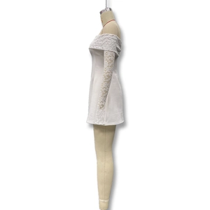 Détail des manches longues en dentelle blanche avec motif floral sur robe bustier