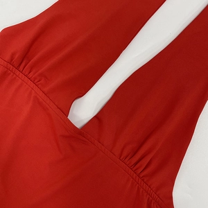 Close-up of red halter neck top featuring deep V-neckline and ruched knit fabric texture