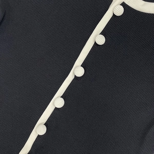 Gros plan détaillé sur la texture tricotée et les boutons du combishort moulant noir