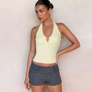 Sexy hellgelbes Neckholder-Top mit Metallring-Detail und grauen Low-Rise-Shorts