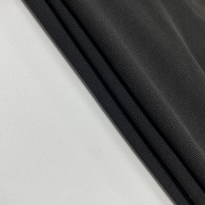 Gros plan sur la maille côtelée noire haute densité montrant la texture du tissu