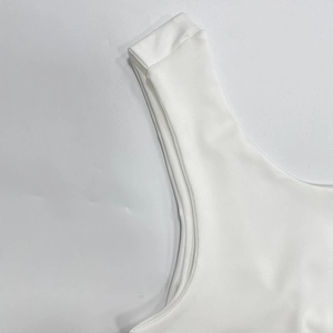 Détail d'un débardeur blanc montrant le tissu en maille épaisse et les coutures soignées