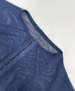 Detail of dark blue mesh bodysuit featuring metal hook-and-eye closures and wavy texture
