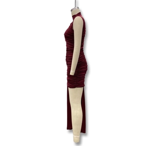 Macro shot of the wine red ruched fabric and high slit detail on the bodycon dress