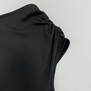 Close-up of pleated shoulder details and elegant black fabric on women's dress