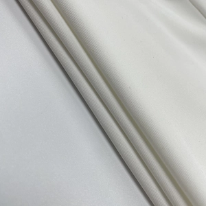 Gros plan sur la texture du tricot blanc montrant le tissage lisse et le toucher doux