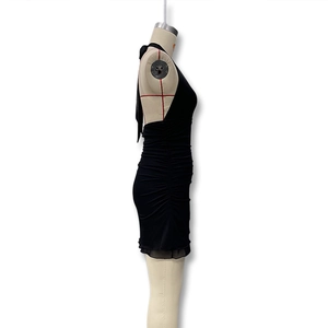 Detail of black bodycon halter dress featuring elegant ruching and ruffled hemline