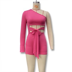 Détail d'une combinaison fuchsia à une épaule avec découpe à la taille et ruban élégant