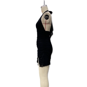Detail of black halter mini dress featuring side ruching and a subtle leg slit design