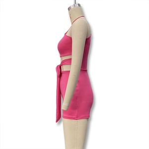 Détail d'un ensemble rose deux pièces avec haut ajouré latéral et short ceinturé sur mannequin