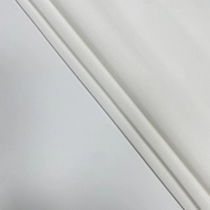 Gros plan sur la texture du tissu en dentelle blanche avec tissage sergé et drapé élégant