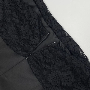 Détail de la fermeture éclair invisible sur une robe en dentelle noire à motif floral