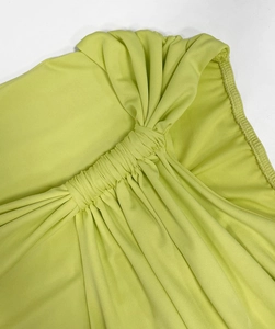 Macro shot of lime green dress featuring detailed gathered ruched fabric and knot design