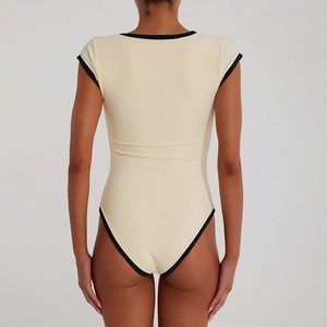 Vue de dos d'un body beige avec bordure contrastée noire et tissu à texture côtelée