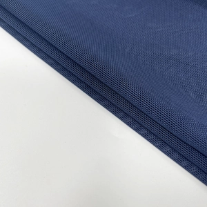 Close-up of navy blue mesh knit fabric with soft texture and refined grid pattern detail